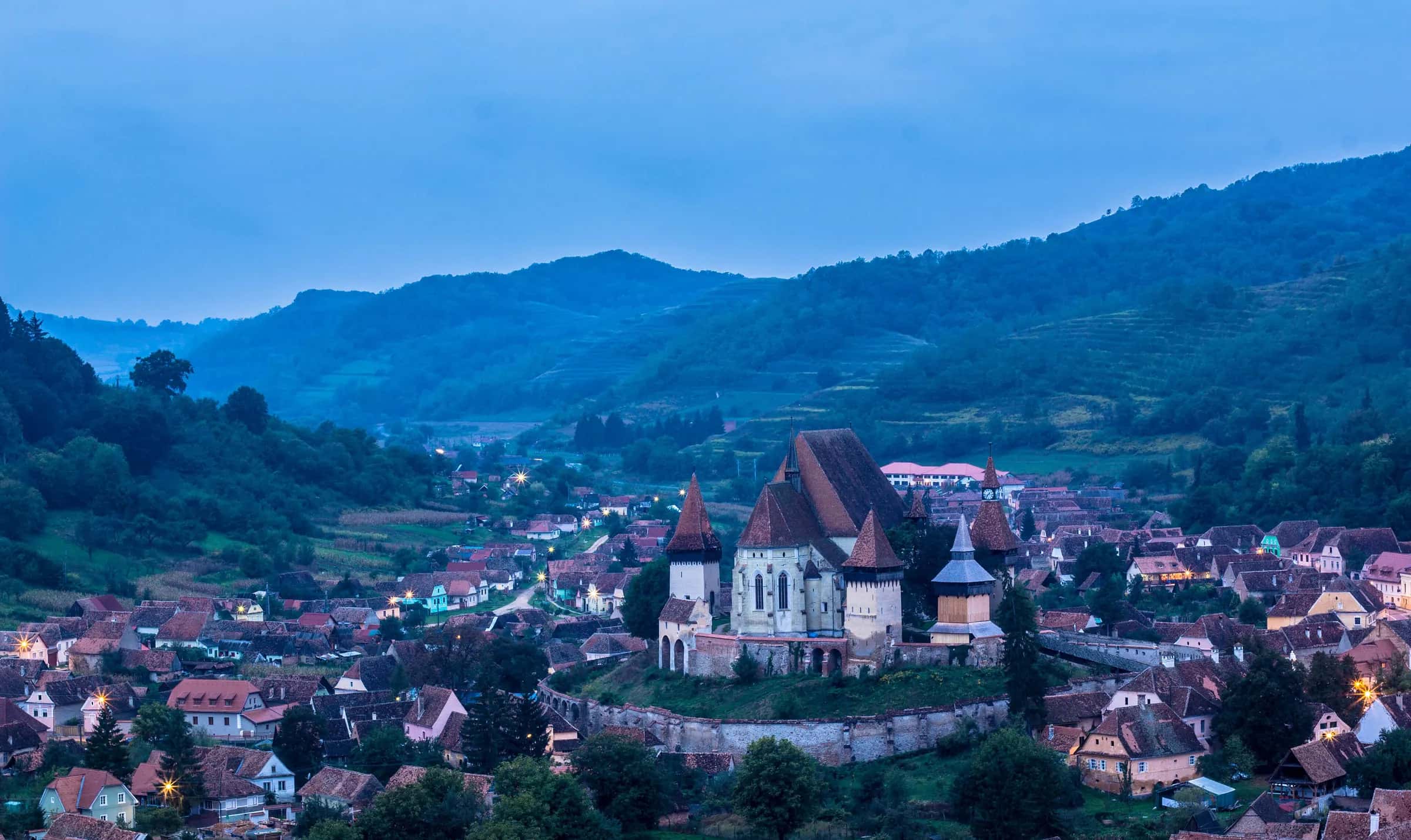 The fortified church of Biertan above its village at blue hour