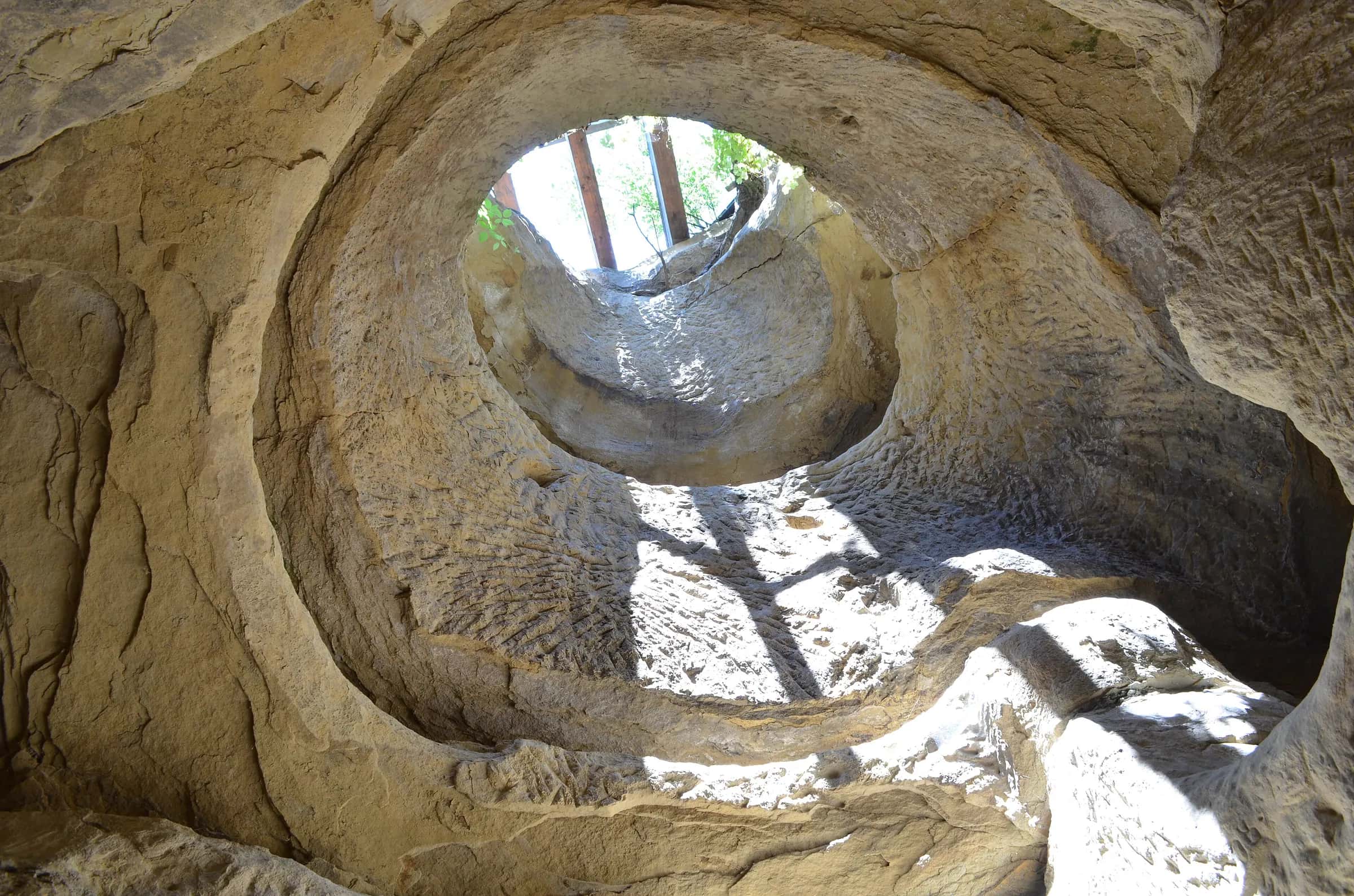 Daylight falling through the round opening of the Șinca Veche rock chapel