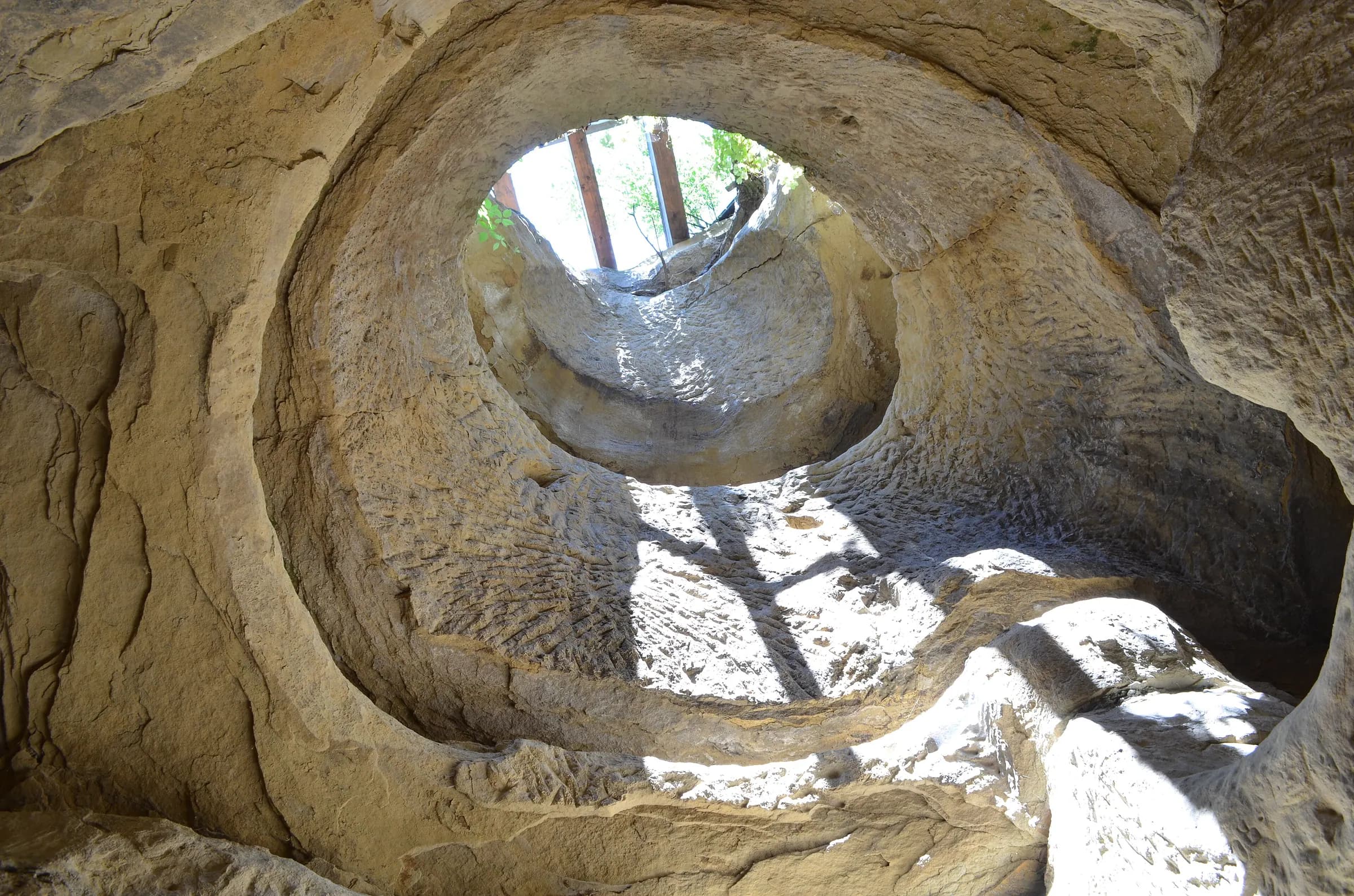 Daylight falling through the round opening of the Șinca Veche rock chapel