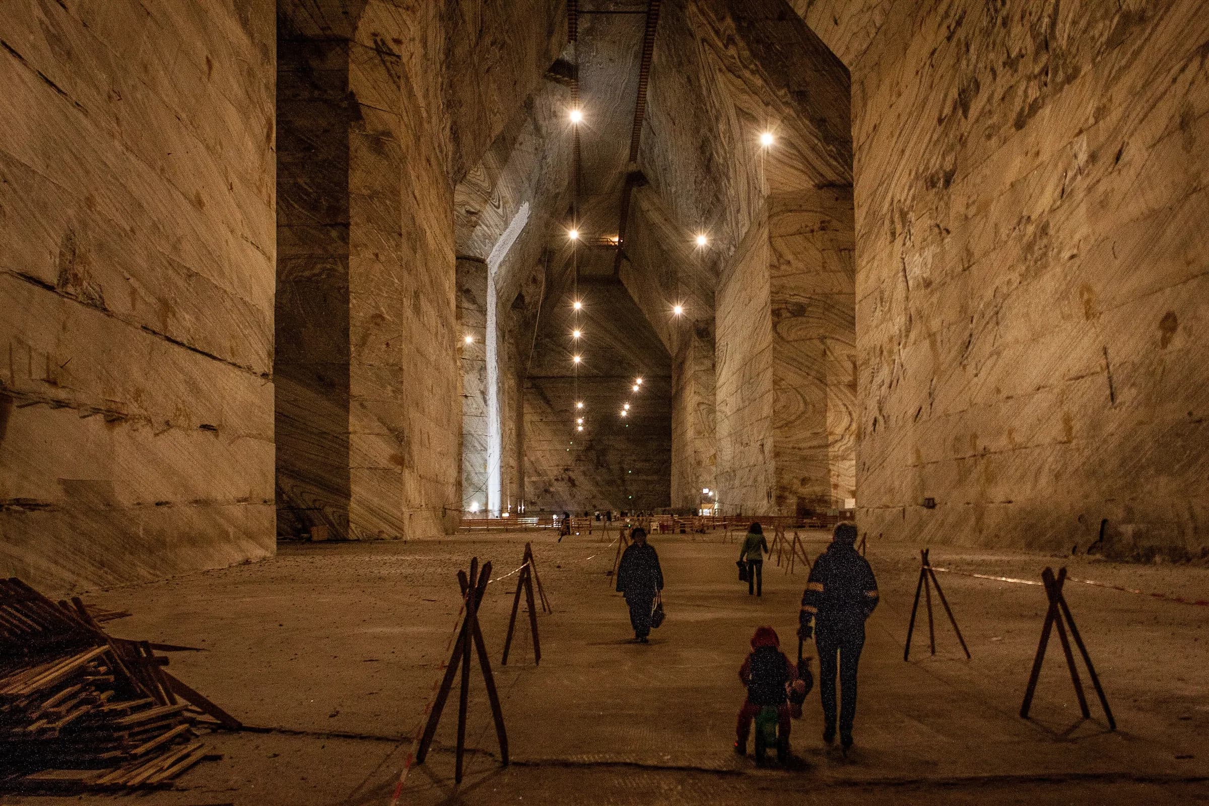 Visitors walking through the vast salt hall of the Slănic mine