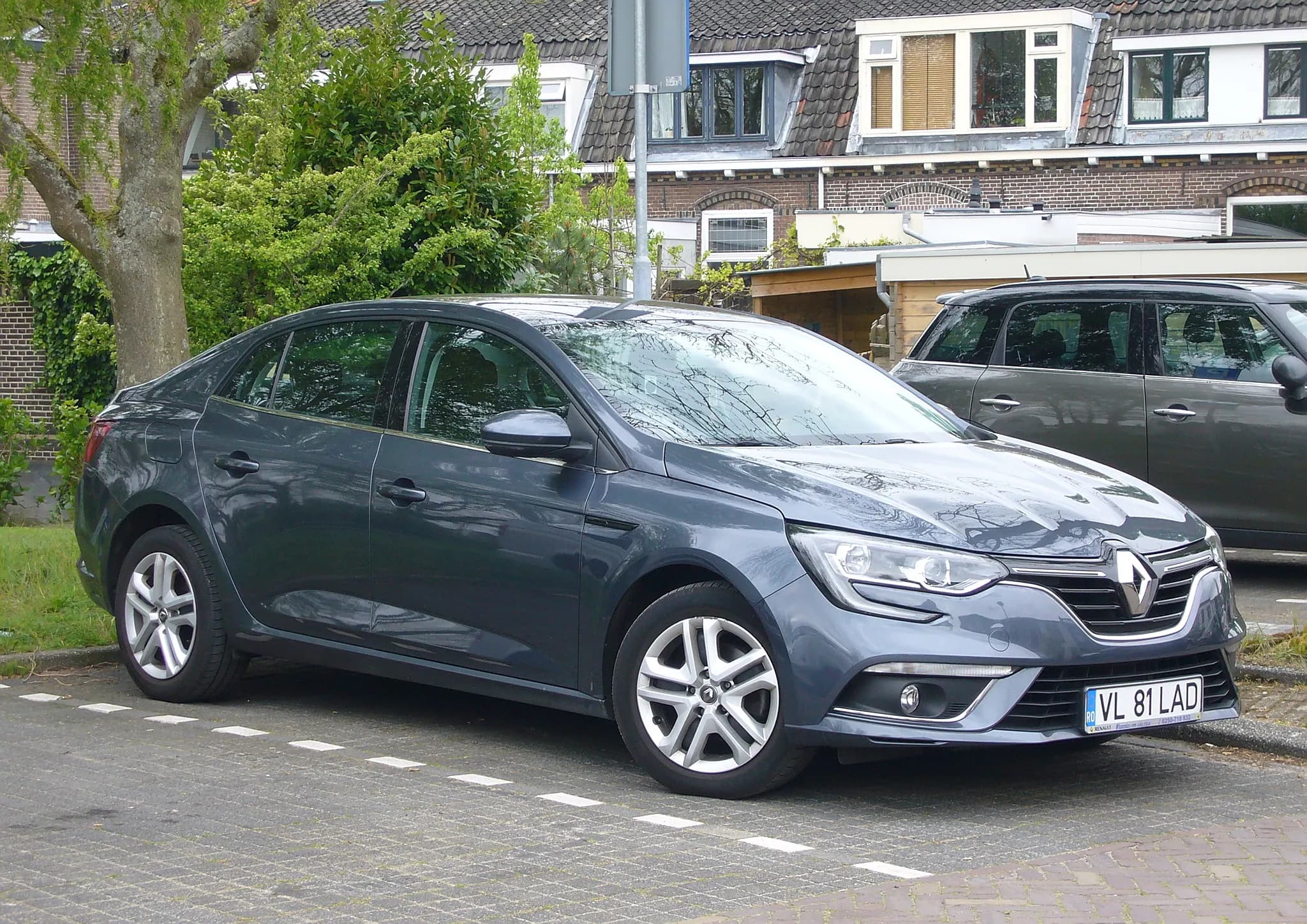 Una Renault Mégane berlina grigia parcheggiata in strada